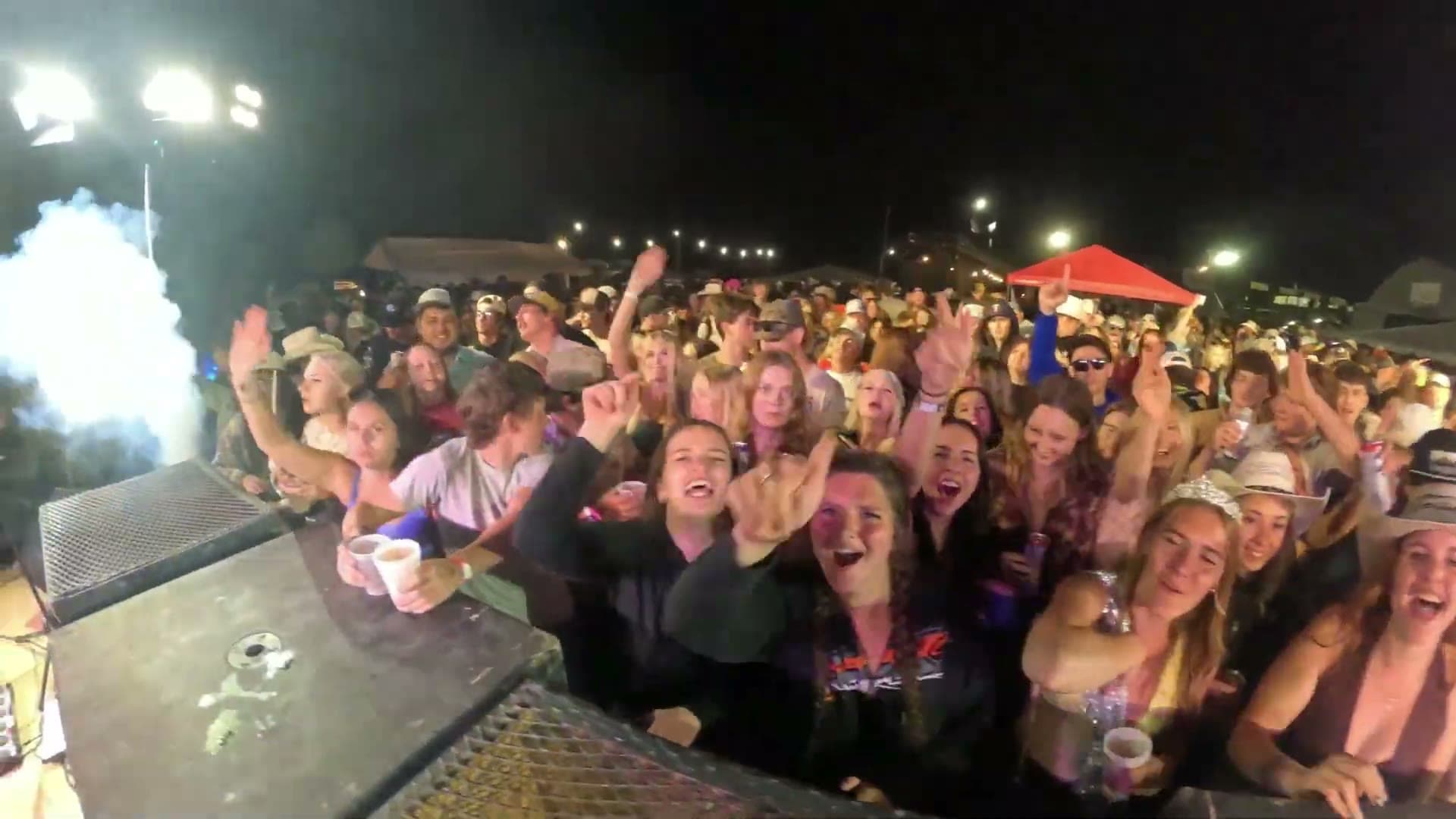 A packed crowd with hands in the air at a Rhyme Or Reason street dance
