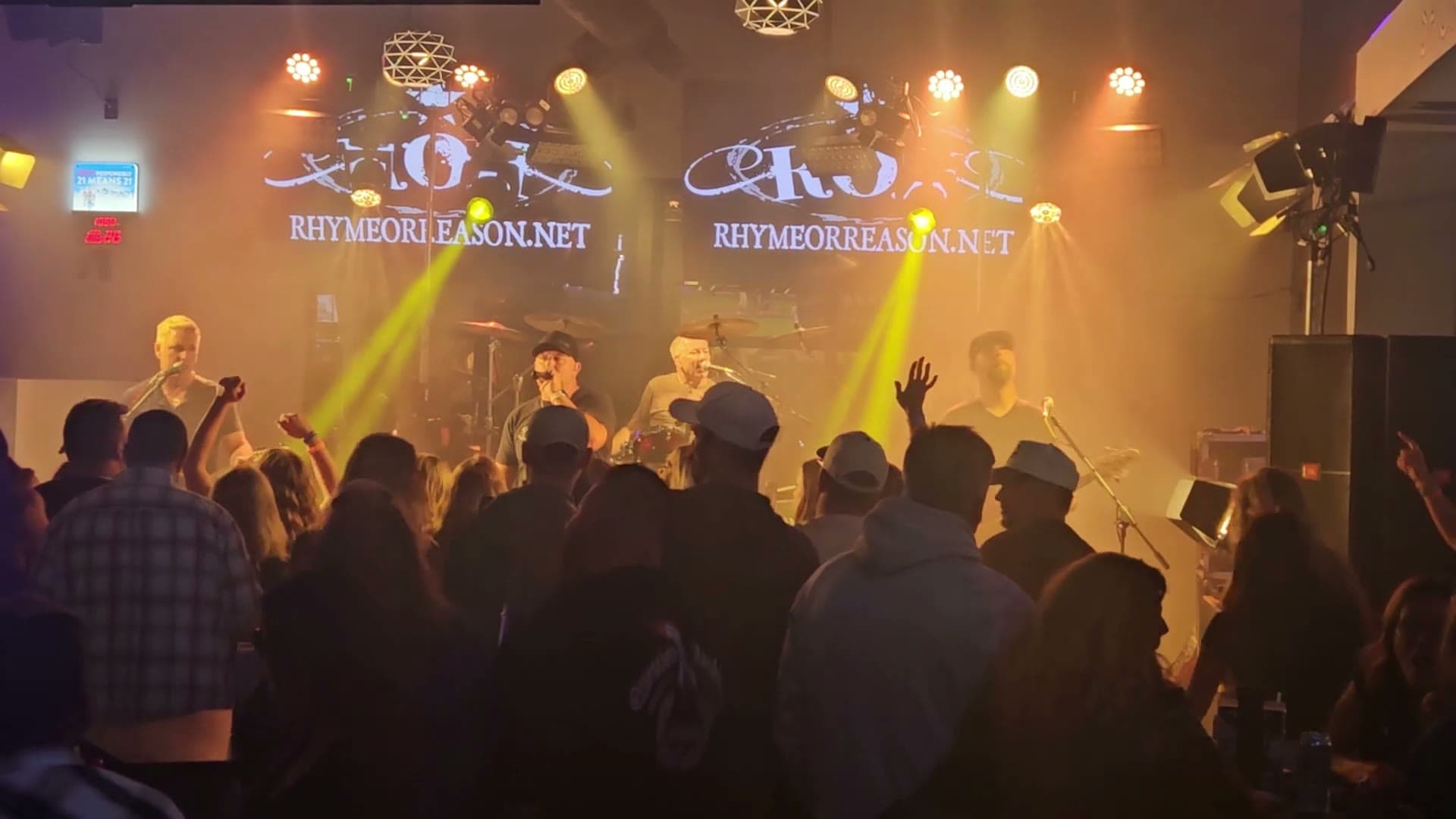 Rhyme Or Reason performing on stage in haze and coloured light