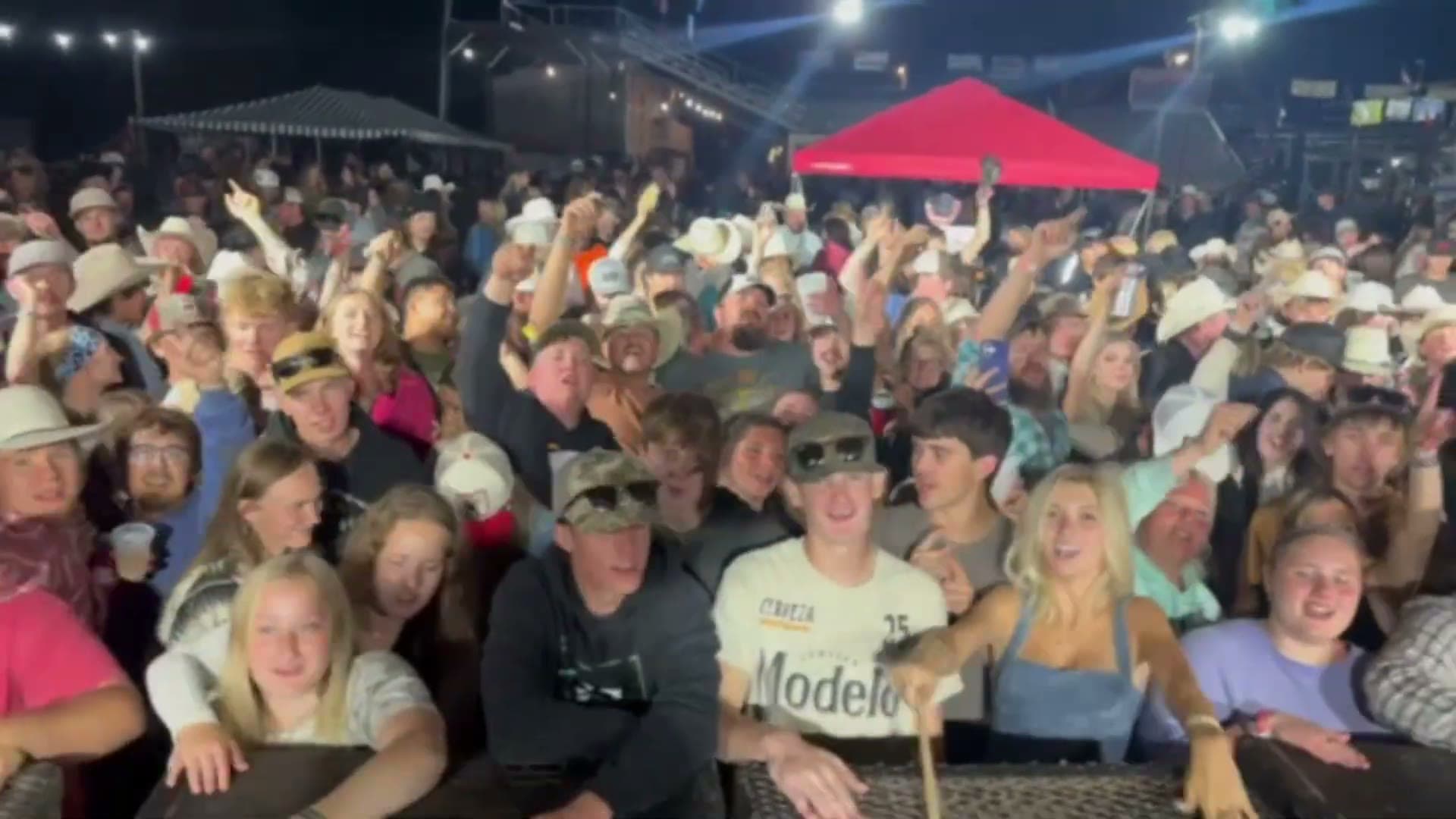 A large crowd packed in front of the stage at an outdoor Rhyme Or Reason show